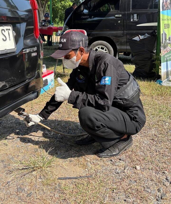 petugas melakukan uji emisi kendaraan, baru-baru ini