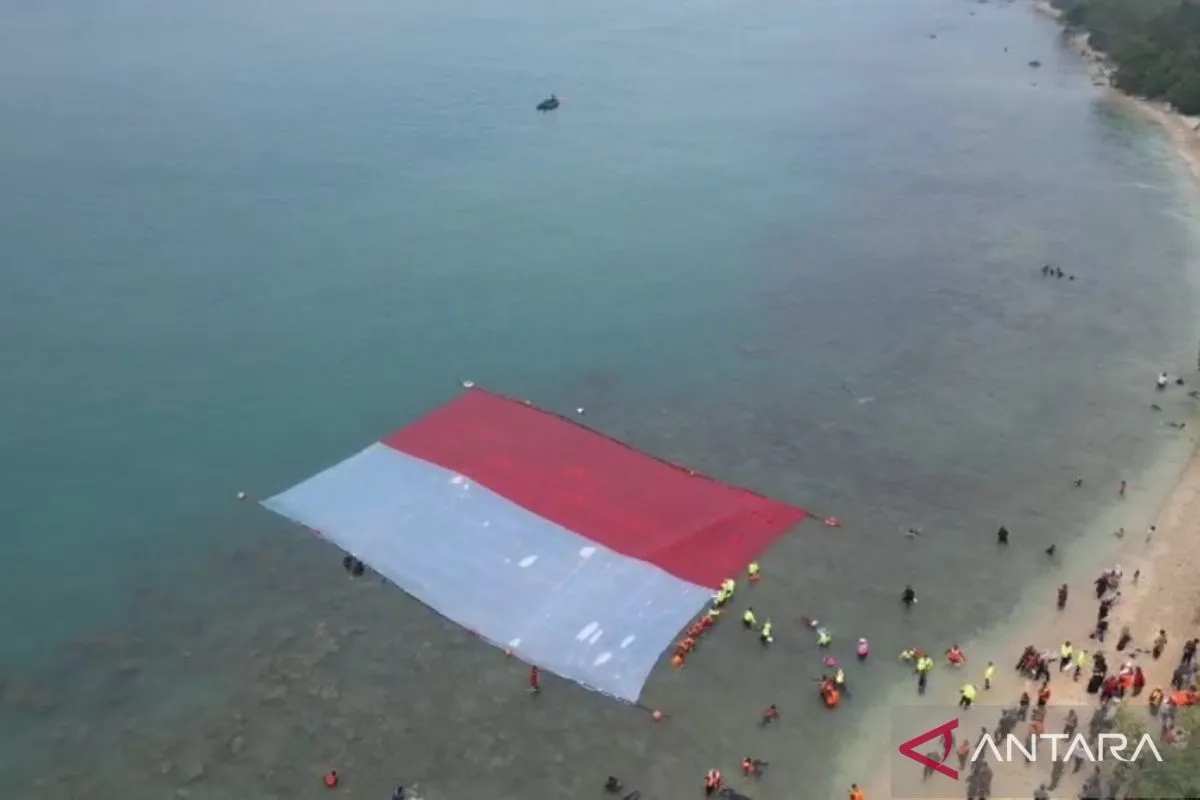 Sejumlah penyelam gabungan membentangkan bendera Merah Putih di perairan laut Merak, Kota Cilegon, Banten.