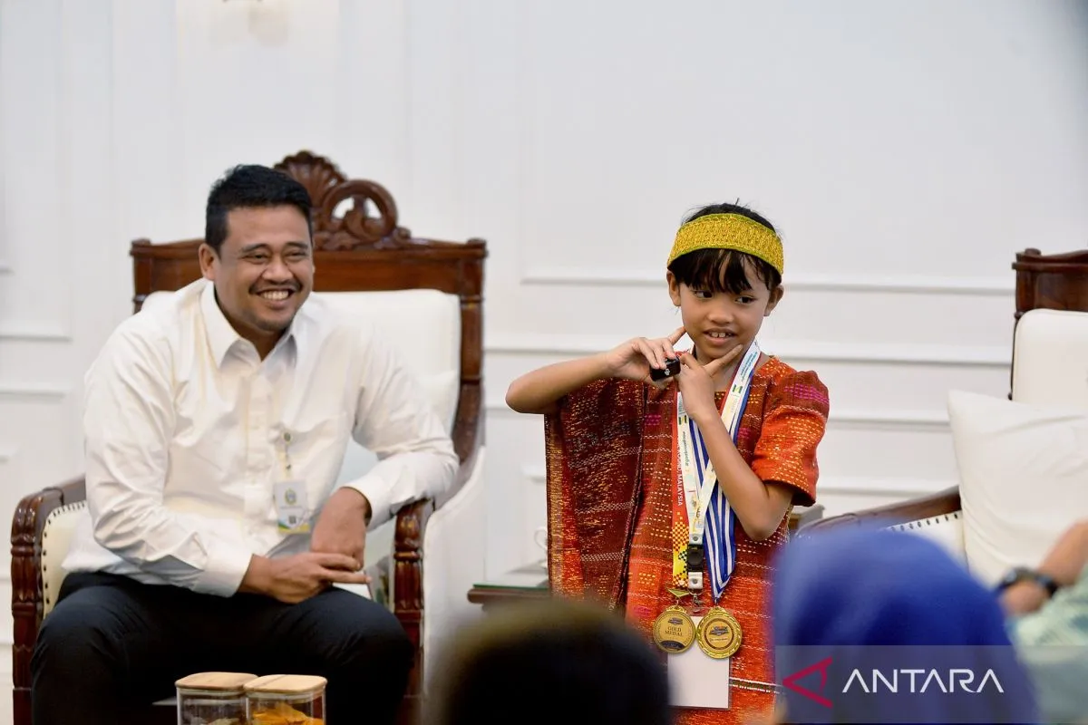 Gubernur Sumatera Utara Bobby Nasution (kiri) menerima Caroline Cicilia Nababan siswi SD Negeri 18 Rantau Selatan meraih medali emas olimpiade sains dan matematika tingkat Asia